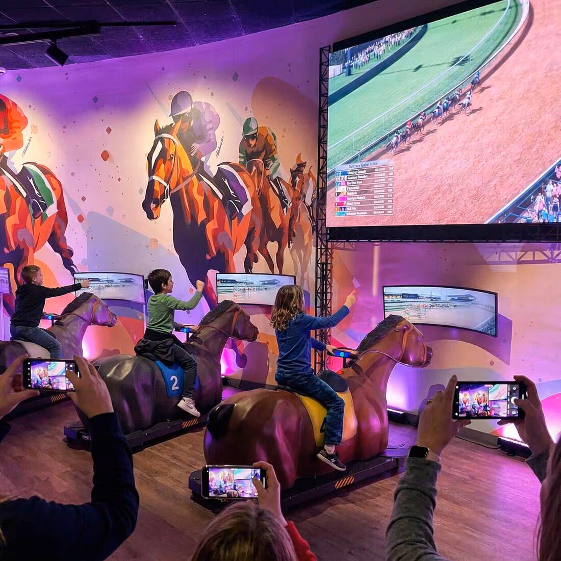 Children riding lifelike horse mounts in the Kentucky Derby motion-platform racing game.