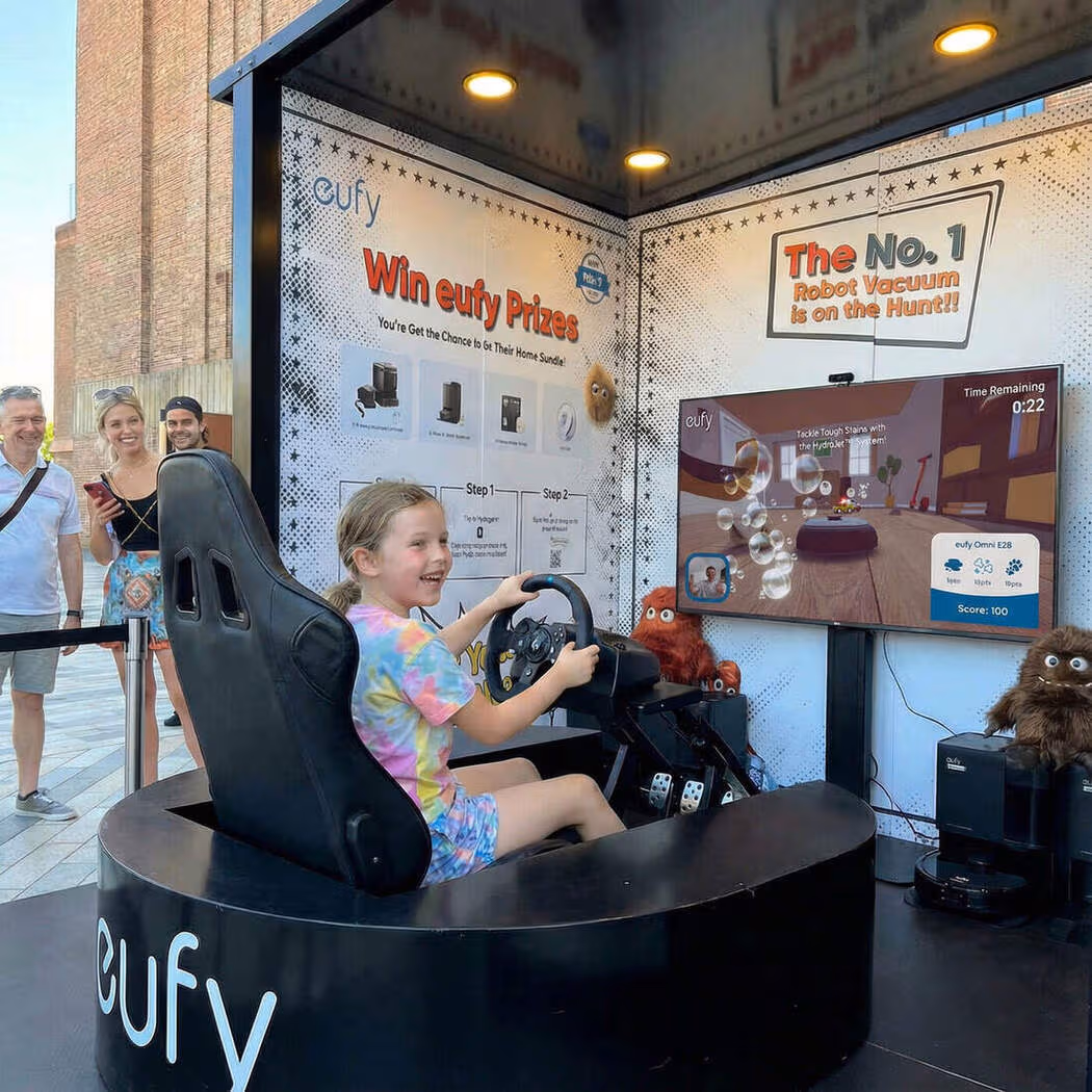 Child playing a Eufy interactive racing game at a branded activation.